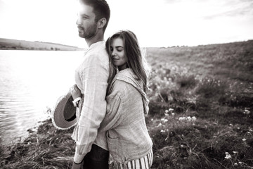 Close up portrait guy and girl hipster travel. Beautiful loving couple having fun, cuddling, smiling on sky background in field.