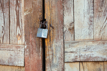 Rusty, cracked lock on an old wooden door of an abandoned house, an abandoned house