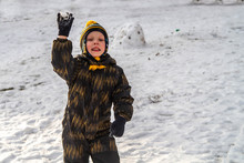 The Boy Made A Snowball To Throw It. War With Snow, Snow Battle Of Children. The Joy And Fun Of The Game.