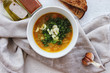 Lentil soup with garlic and herbs in a white bowl on the table. Diet, home-cooked food.