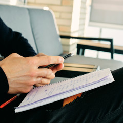 Wall Mural - young man using a smartphone while taking notes