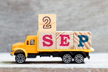 Wall Mural - Truck hold letter block in word 2sep on wood background (Concept for date 2 month september)