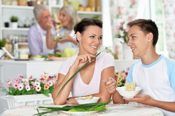 Wall Mural - Portrait of mother and son eating at kitchen