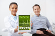 © LIGHTFIELD STUDIOS - selective focus of african american dentist holding digital tablet with medical app on screen near happy patient