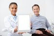 © LIGHTFIELD STUDIOS - selective focus of cheerful african american dentist holding digital tablet with white screen near happy patient