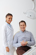 © LIGHTFIELD STUDIOS - happy patient smiling with african american dentist in braces