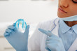 © LIGHTFIELD STUDIOS - cropped view of african american dentist pointing with finger at retainer
