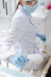 © LIGHTFIELD STUDIOS - selective focus of african american dentist in medical mask and face shield taking stainless dental instrument