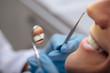 © LIGHTFIELD STUDIOS - cropped view of dentist in latex gloves holding dental instruments near smiling man