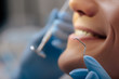 © LIGHTFIELD STUDIOS - cropped view of dentist in latex gloves holding dental instruments near cheerful man