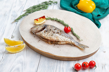 well-fried dorado fish in a plate on a wooden table