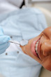 © LIGHTFIELD STUDIOS - top view of orthodontist in latex glove holding dental mirror near happy african american patient in braces