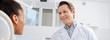© LIGHTFIELD STUDIOS - panoramic shot of happy dentist looking at african american patient