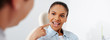 © LIGHTFIELD STUDIOS - panoramic shot of african american woman with opened mouth pointing with finger at braces near orthodontist in clinic