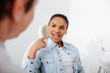 © LIGHTFIELD STUDIOS - selective focus of african american woman with opened mouth pointing with finger at braces near orthodontist in clinic