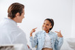 © LIGHTFIELD STUDIOS - selective focus of happy african american woman pointing with fingers at braces near orthodontist in clinic