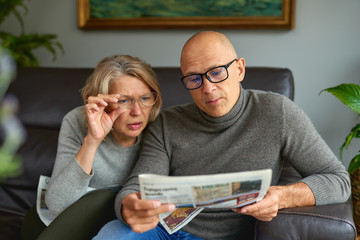 Adult woman and man reading newspaper.News, press, media, holidays and people concept .