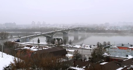 Wall Mural - Nizhny Novgorod, Russia. Aerial view of historical buildings in popular touristic city Nizhny Novgorod, Russia with cloudy sky in winter. Cars at the bridge over river