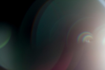 Fototapete - Colourful lens flare on black background.