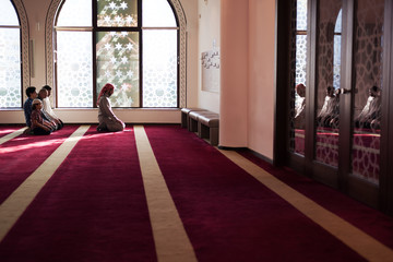 Wall Mural - Group of young Muslim people praying. Muslim prayers doing a pray inside the mosque.