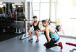 © Luis Manuel Matias/ADDICTIVE STOCK - Powerful determined sportsman doing exercise with barbell at squat rack during weightlifting training with personal coach in modern gym