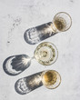 © Olga Vila/ADDICTIVE STOCK - Top view composition of various glasses with alcohol drinks in sunlight leaving shadows and lights on marble surface