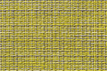 The Table Mat Is Yellow, Woven From Thin Plastic Rods.