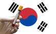 © Ridvan - COVID-19 Pandemic Coronavirus concept ; Close-up of a Positive COVID-19 blood test sample tube with Flag of South Korea at background. Blood testing for diagnosis new Corona virus infection.