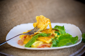 Sticker - fried home omelet with vegetables and arugula in a plate