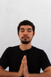 © Antonio Tanaka - young hispanic man wearing black sportswear meditating in a yoga session in the lotus flower pose , at home