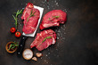 © александр таланцев - raw beef steaks with spices, raw steak on a knife on a stone background