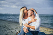 © Daria - Lifestyle romantic evening for two. Young lovers went on a trip to the sea. Sitting on the sand in the evening sun and hugging, talking, kissing and enjoying the absence of people around.