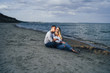 © Daria - Lifestyle romantic evening for two. Young lovers went on a trip to the sea. Sitting on the sand in the evening sun and hugging, talking, kissing and enjoying the absence of people around.