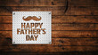 Happy Father's Day text and hipster mustache punched into  with background with copy space. Ideal for social media promotion, email or website graphic.