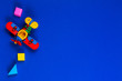 © vejaa - Baby kids educational toys background. Red plane and wooden cubes on navy blue background. Top view, flat lay