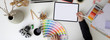 © bongkarn - Overhead shot of designer working on mock-up digital tablet, designer supplies and decorations