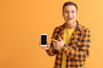 Wall Mural - young man with mobile phone on color background