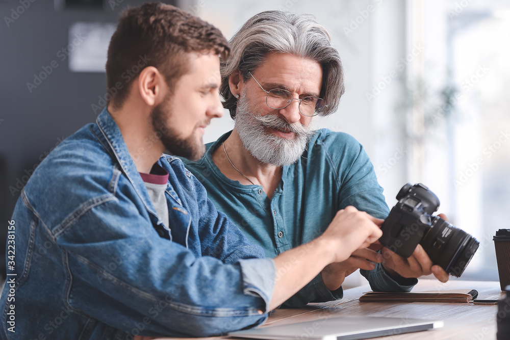 Mentor teaching young photographer in studio
