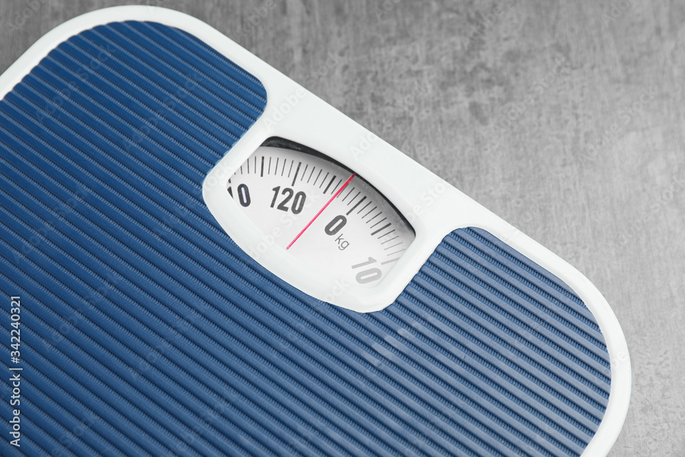 Weight scales on grey background, closeup. Slimming concept