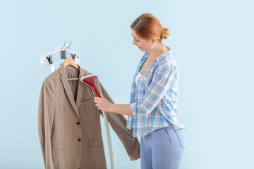 Poster - Worker of modern dry-cleaner's on color background