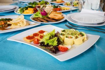 Sticker - salmon rolls, sandwiches with red caviar and other snacks on the festive table