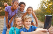 © Monkey Business - Group Of Multi-Cultural Children Posing For Selfie With Friends In Countryside Together
