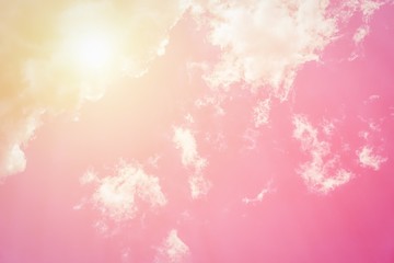 Wall Mural - Sunny orange pink sky background. Beautiful warm sky with clouds. Toned photo