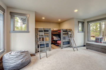 Living room luxury interior with two kids bunk beds  and brown velvet sofas and grey carpet and large windows.