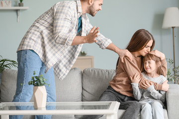 Wall Mural - Angry husband threatening his wife and daughter at home