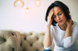 © My Ocean studio - Severe pain. Close-up photo of a beautiful woman, who is touching her forehead and the back of her neck, while suffering from headache.