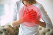 © My Ocean studio - Heart attack. Close-up photo of woman's hands touching her heart area highlighted in red, while she is suffering from chest pain.