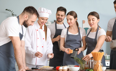 Canvas Print - Female chef and group of young people during cooking classes