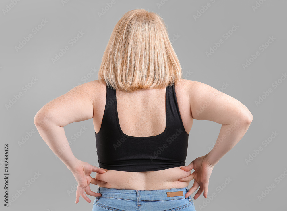 Overweight woman on grey background
