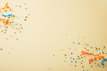 top view of festive colorful confetti on beige background